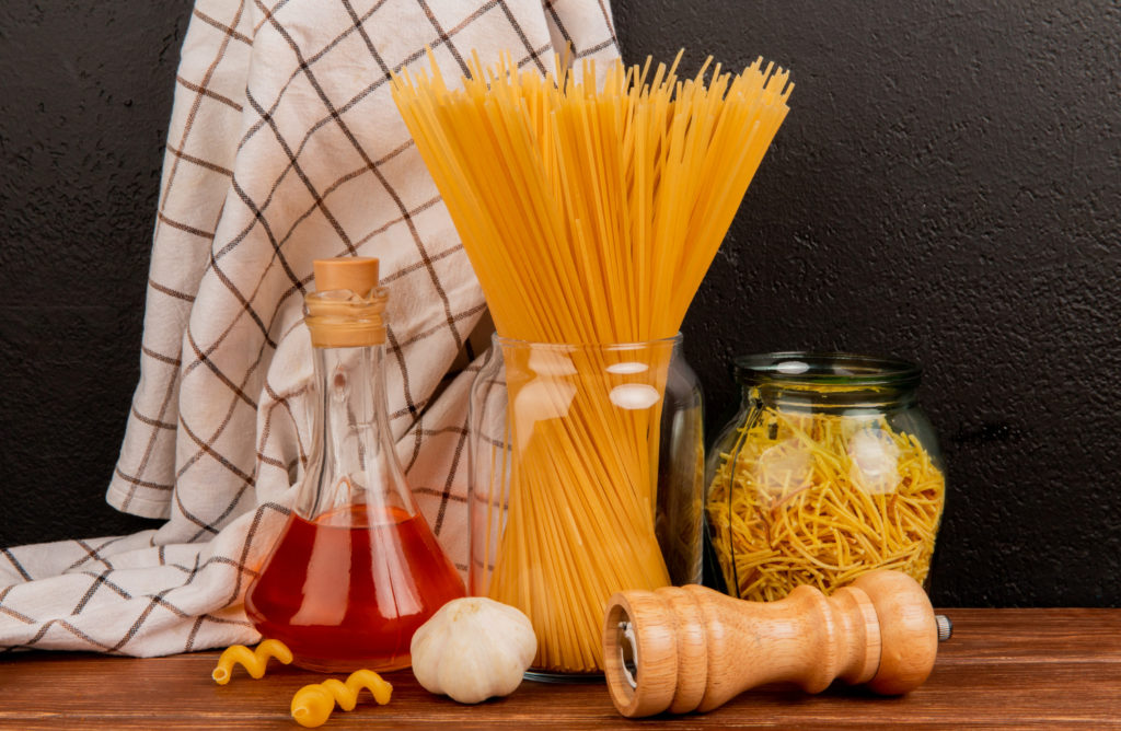 side-view-spaghetti-pasta-jars-with-melted-butter-garlic-salt-plaid-cloth-wooden-surface