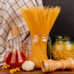 side-view-spaghetti-pasta-jars-with-melted-butter-garlic-salt-plaid-cloth-wooden-surface