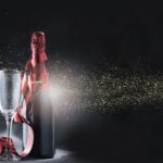 wine-bottle-glasses-with-red-ribbon-golden-glitters-960x668