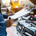 auto-mechanic-inspecting-car-filling-out-paperwork_1244150-6728