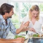 cute-smiling-couple-having-meal-together-home-dining-room-42534259