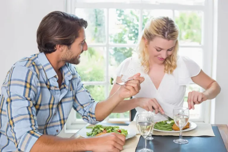 cute-smiling-couple-having-meal-together-home-dining-room-42534259